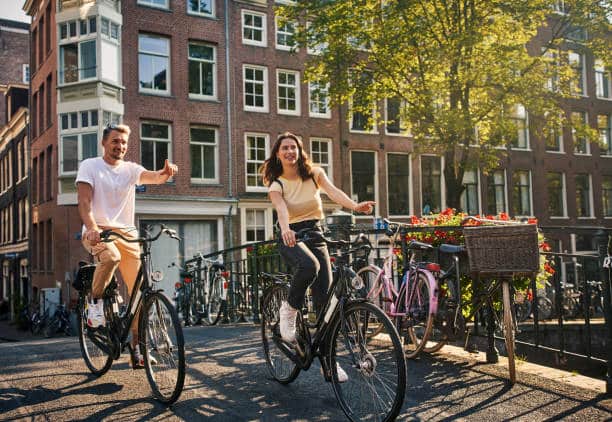 Shot of a young couple exploring the city of Amsterdam by bike