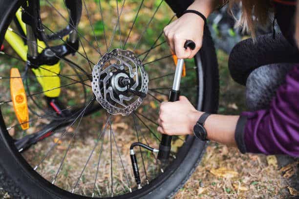 Woman repairing her bicycle outdoor.
