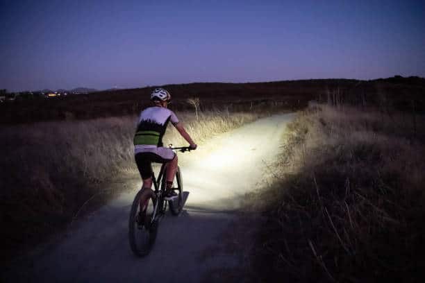 Night MTB Rider With A Light At Sunset