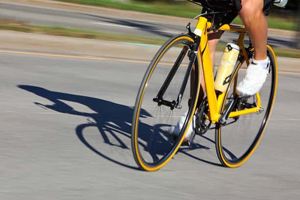 A professional cyclist with background blur to show speed. Shadow shows full cyclist.