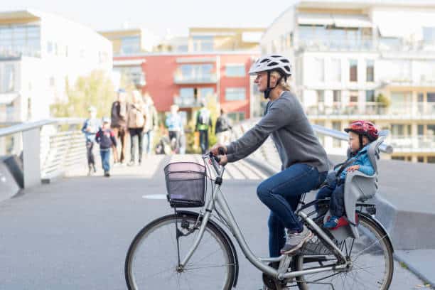 man riding e-bike on the street with his child on the backseat