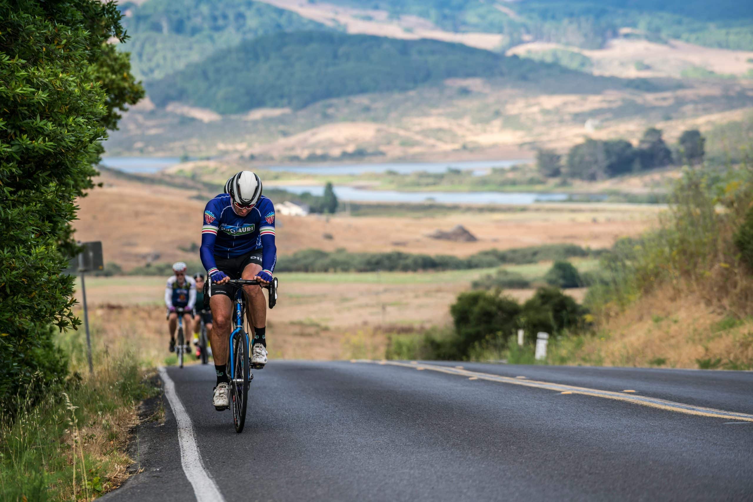 2 people riding up a hill with an e-bike